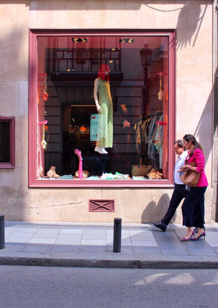 A couple walking infront of a shop