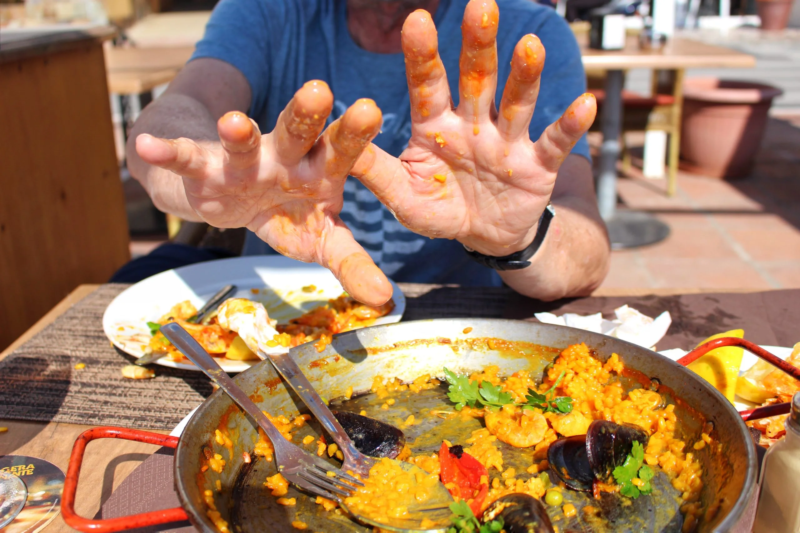 While in Spain, it's always a good idea to enjoy a good paella - Flying Baguette A man partaking a paella dish