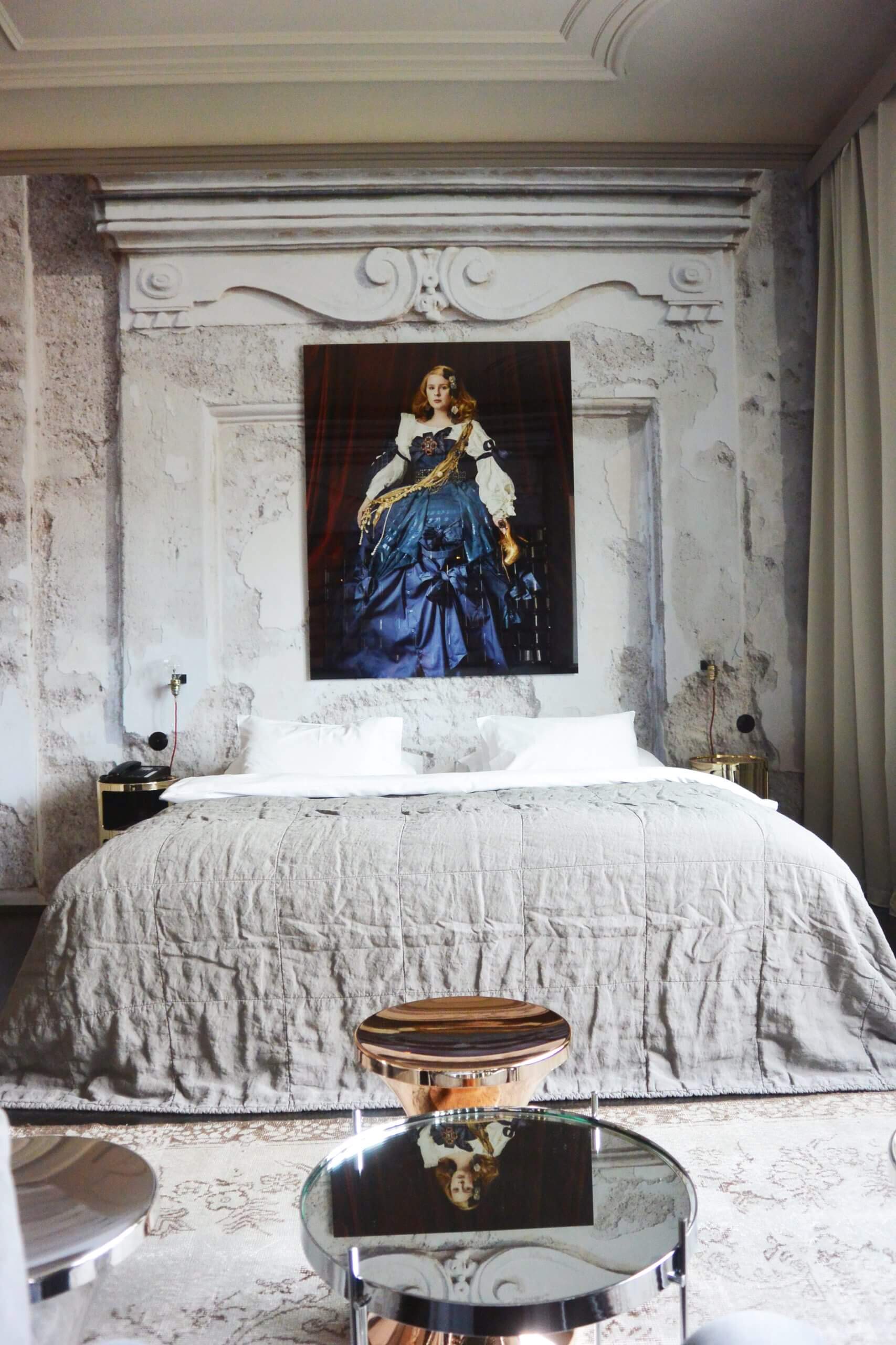 A cozy bed and a picture frame hanging from above